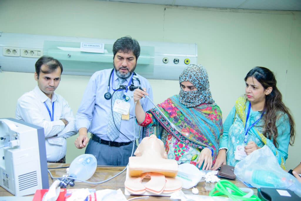 Dr. Asim Rana demonstrating intubation technique to trainees