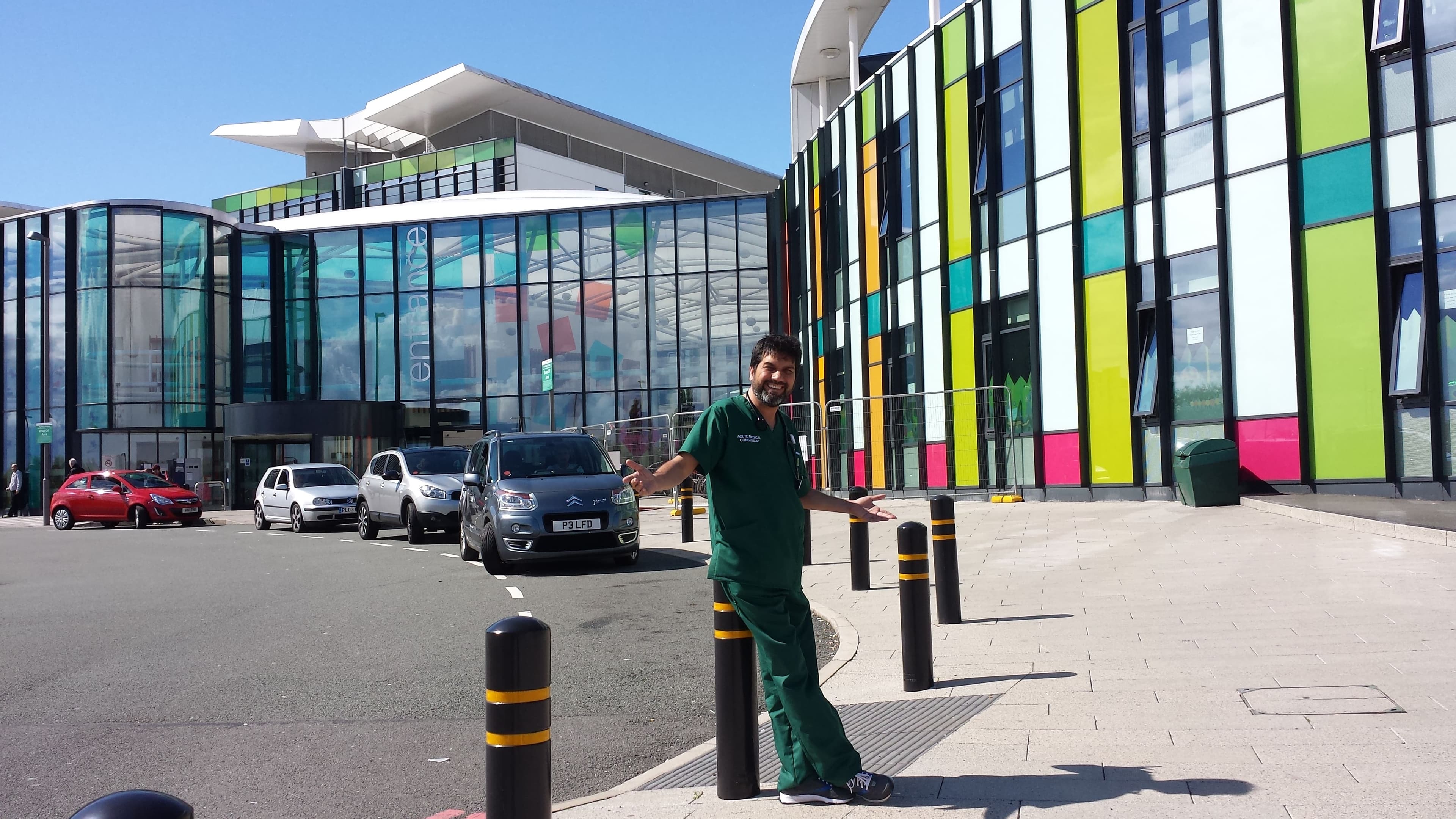 Dr. Asim Rana in scrubs standing outside a hospital entrance