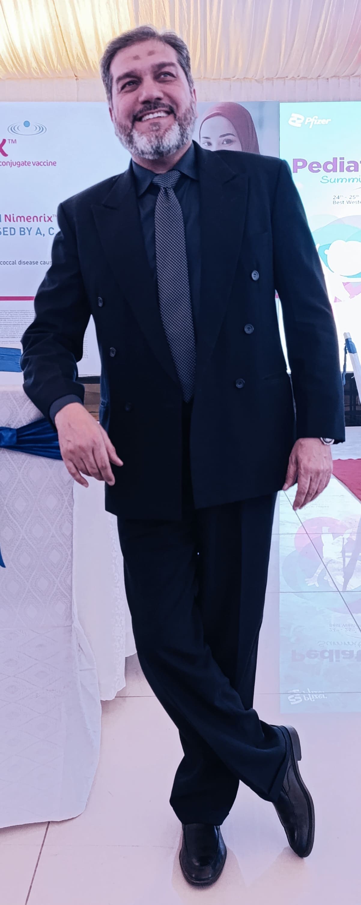 Dr. Asim Rana in a formal suit at a medical summit